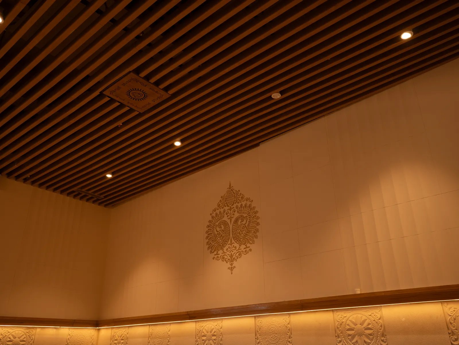 Timber-slat ceiling over a carved feature wall — Chalukya Samrat
